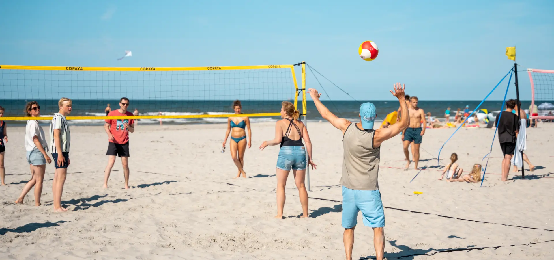 Groepje volleyballen strand Vakantiewerk Duinoord Ameland 2024