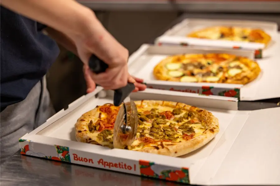 Medewerker bereidt pizzas horeca duinoord ameland
